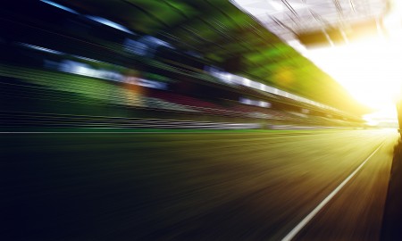 Foward motion speed lens blur racing circuit background with seated stand , sunset scene  .